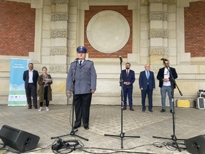 na zdjęciu komendant w trakcie przemówienia na scenie, za nim goście i prowadzący uroczystość