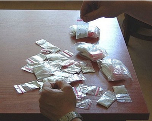 na zdjęciu woreczki strunowe z białym proszkiem na blacie biurka