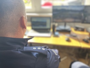 na zdjęciu policjant przy monitoringu