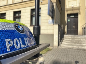 na zdjęciu napis policja na motocyklu, w tle wejście do komendy