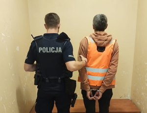 na zdjęciu policjant z zatrzymanym w pomieszczeniu