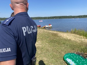 na zdjęciu policjant obserwuje akwen wodny