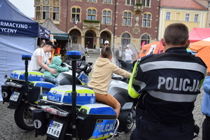 Na zdjęciu widać policjanta, motocykle oraz policyjne stoisko