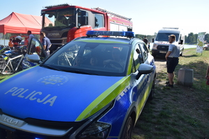 Na zdjęciu widoczni uczestnicy pikniku, radiowóz i motocykle