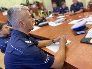 na zdjęciu policjanci przy dużym stole w trakcie odprawy do zabezpieczenia biegu