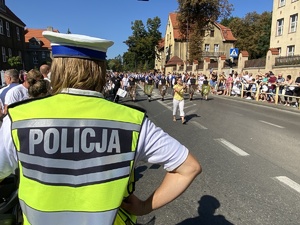 na zdjęciu policjant obserwujący widownię i pochód