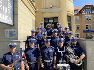 na zdjęciu członkowie orkiestry komendy wojewódzkiej policji w Katowicach na schodach prowadzących do budynku komendy powiatowej