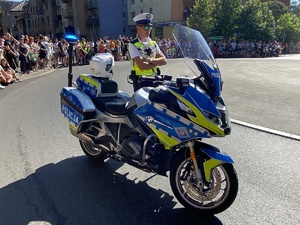 na zdjęciu policjant przy policyjnym motocyklu na rondzie w trakcie zabezpieczenia historycznego pochodu