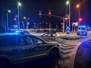 na zdjęciu policyjne radiowozy z włączonymi sygnałami świetlnymi na skrzyżowaniu, gdzie doszło do wypadku