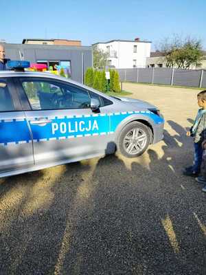 na zdjęciu policjant z dziećmi przy radiowozie