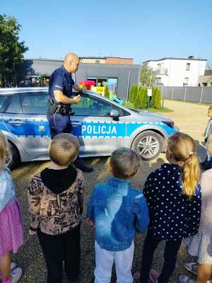 na zdjęciu policjant z dziećmi przy radiowozie