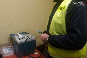na zdjęciu policjant w kamizelce przy alkomacie