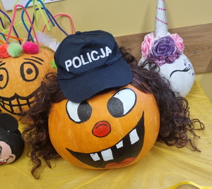 na zdjęciu dynia halloween&#039;owa z czapka z napisem policja