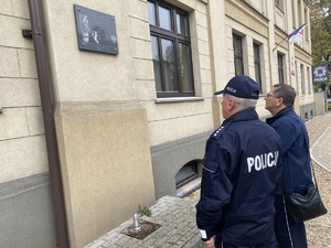 na zdjęciu komendant i kapelan pod pamiątkową tablicą