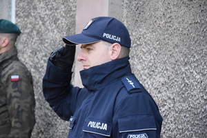 na zdjęciu policjant oddający honor