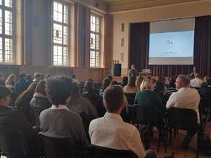 na zdjęciu aula szkolna, w której prowadzone jest spotkanie