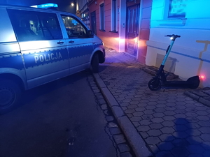 na zdjęciu radiowóz i obok hulajnoga elektryczna zaparkowana na chodniku