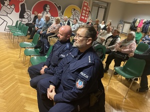 na zdjęciu policjanci i seniorzy siedzący na krzesłkach