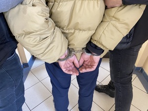 na zdjęciu ręce zatrzymanego skute kajdankami