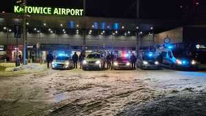na zdjęciu policjanci i strażnicy graniczni przy radiowozach przed lotniskiem