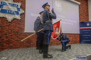 na zdjęciu komendant główny klęcząc całuje sztandar