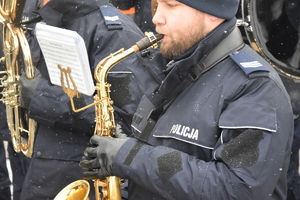Na zdjęciu widoczny policjant grający na instrumencie