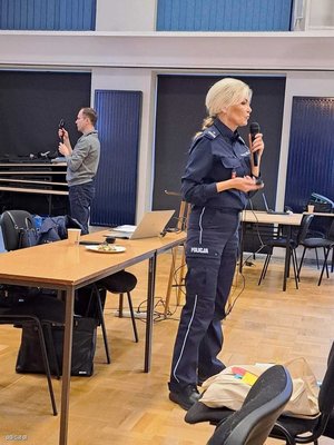 na zdjęciu policjantka z mikrofonem w ręku