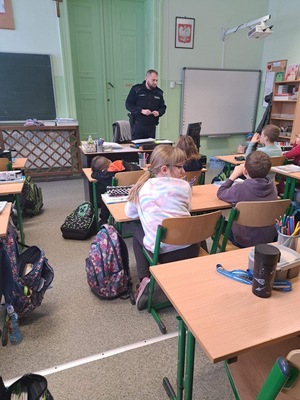 na zdjęciu policjant w sali lekcyjnej przed uczniami prowadzący prelekcje