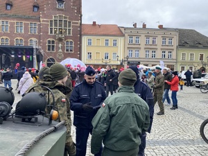 na zdjęciu policjanci rozmawiający z żołnierzami, za nimi inne osoby na płycie rynku