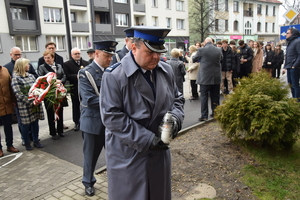 na zdjęciu komendant policji w trakcie składania znicza pod tablicą