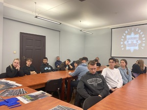 na zdjęciu uczniowie w sali narad w trakcie spotkania, za nimi na ścianie wyświetlana gwiazda policyjna z napisem pomagamy i chronimy policja tarnowskie góry