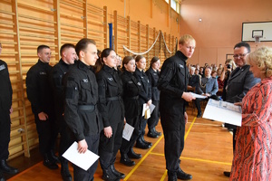 na zdjęciu komendant policji w trakcie wręczania uczniom certyfikatów