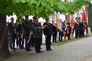 na zdjęciu delegacje kwiatowe w trakcie przejścia pod pomnik