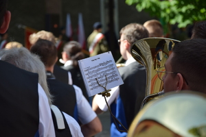 na zdjęciu książka z nutami na instrumencie, na której widać napis witaj maj, 3 maj, w tle inne osoby