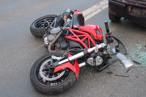 na zdjęciu leżący na ziemi uszkodzony motocykl
