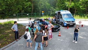 na zdjęciu policyjne radiowozy i motocykl, a przy nim policjanci i inne osoby