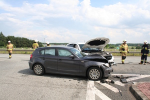 na zdjęciu dwa rozbite pojazdy na drodze, obok strażacy i inne osoby