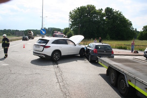 na zdjęciu dwa rozbite pojazdy na drodze, obok strażacy i inne osoby