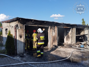 na zdjęciu spalony budynek a przy nim strażacy