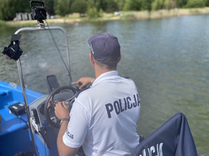 na zdjęciu policjant za sterami policyjnej motorówki