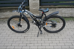 na zdjęciu rower na chodniku przy płocie