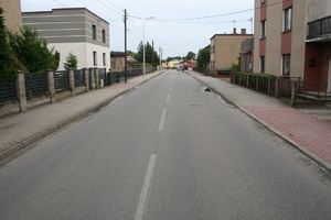 na zdjęciu fragment drogi z zabudowaniami