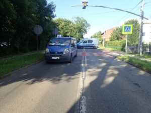 na zdjęciu niebieski bus na jezdni za nim przejście dla pieszych i policyjny radiowóz