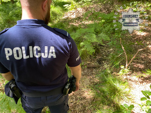 na zdjęciu policjant przy pocisku w lesie