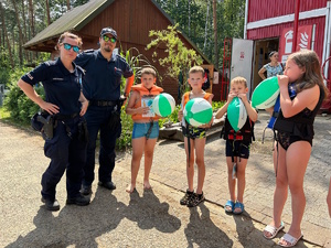 na zdjęciu policjant i policjantka dziećmi