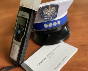 na zdjęciu alkomat, bloczek mandatowy i policyjna czapka