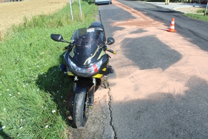 na zdjęciu motocykl zaparkowany przy jezdni na poboczu