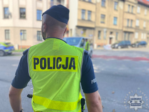 na zdjęciu policjant w odblaskowej kamizelce na trasie biegu