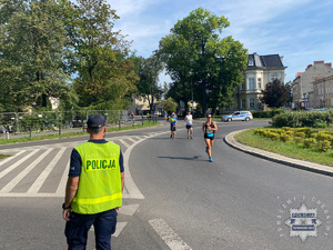 na zdjęciu policjant w odblaskowej kamizelce na trasie biegu