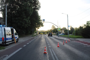 na zdjęciu fragment drogi, na którym stoi radiowóz, inne pojazdy i osoby, widoczne także słupki oddzielające od miejsca zdarzenia